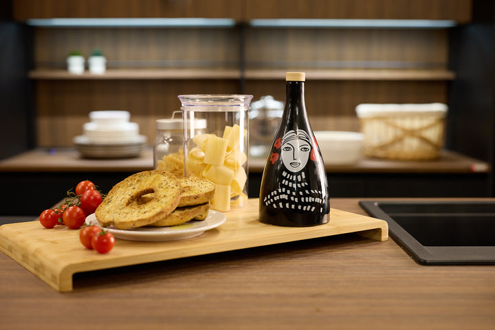 Ceramic olive oil bottles in black and white with hand painted design on a kitchen table