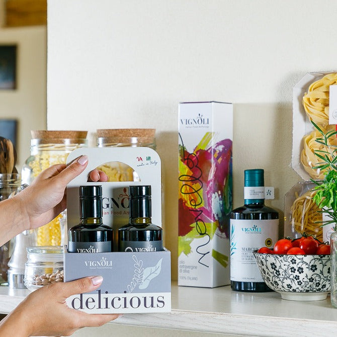 Vignoli SUMMER MEMORIES Serving Set with front view of 2 bottles of infused extra virgin olive oil and 2 bottles of infused balsamic vinegar Modena being placed on shelf in kitchen