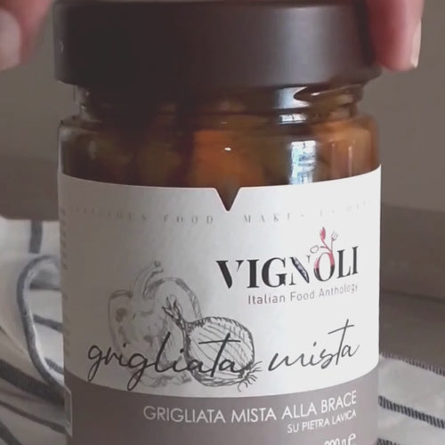 Mixed Grill Vegetables in Olive Oil front of 10.22oz jar being opened and spooned out