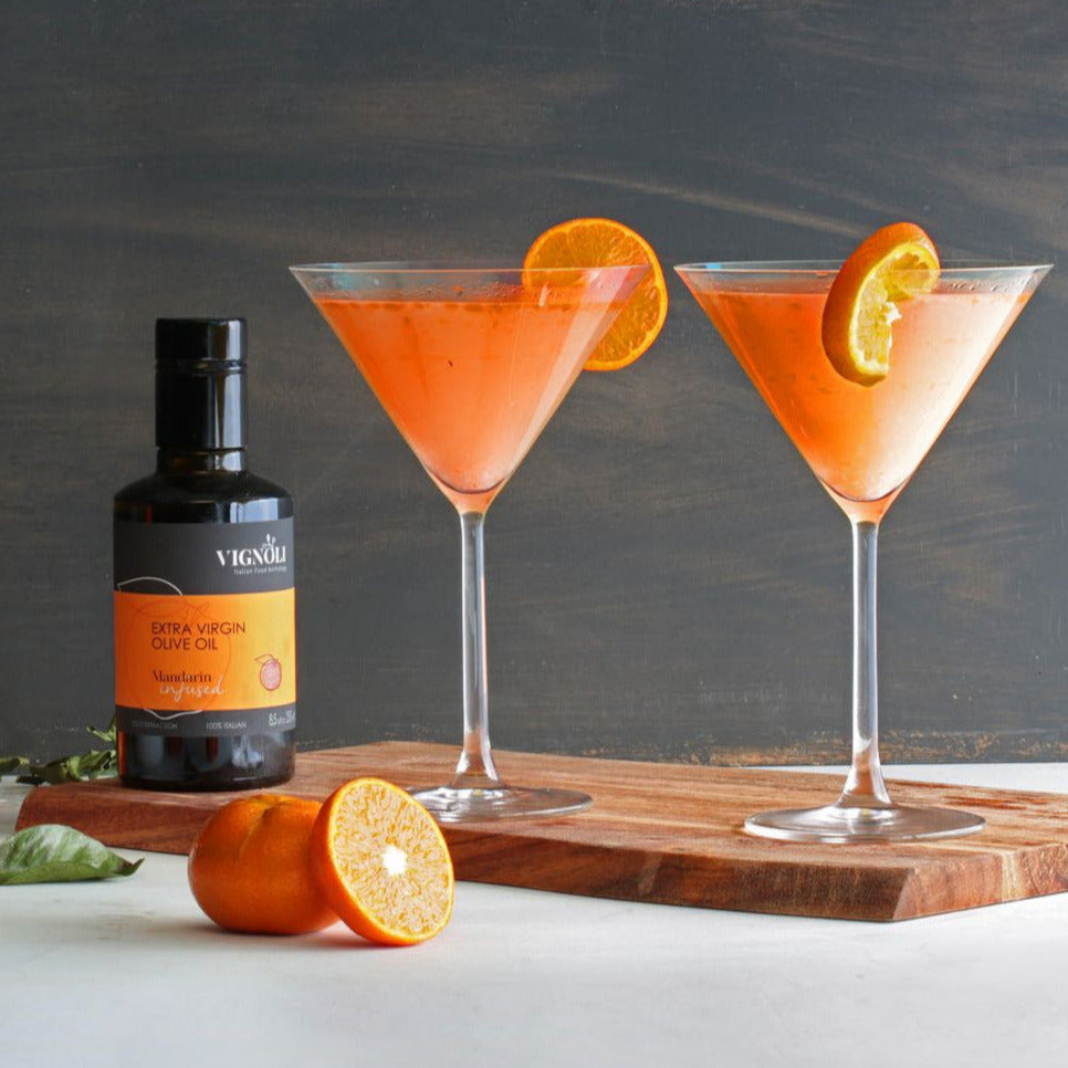 Vignoli Mandarin Infused Extra Virgin Olive Oil front of 8.5oz bottle with mandarin martinis on table