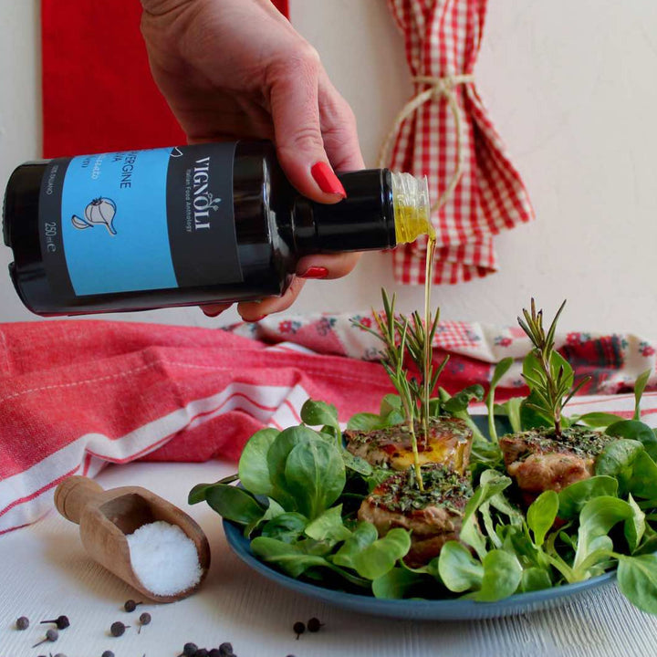 Black Garlic Infused Extra Virgin Olive Oil front of 8.5oz bottle pouring over meat