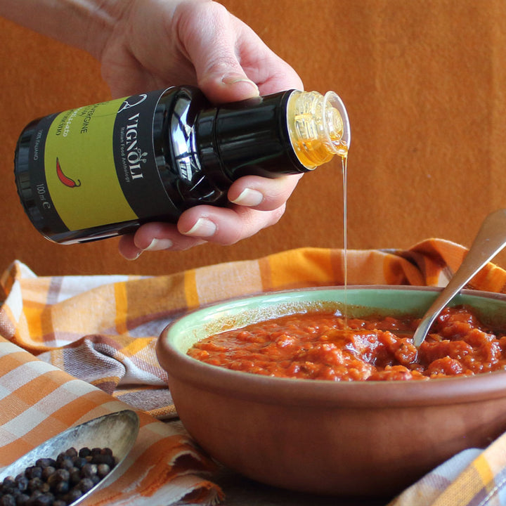 Chili Pepper Infused Extra Virgin Olive Oil front of 8.5oz bottle pouring into bowl