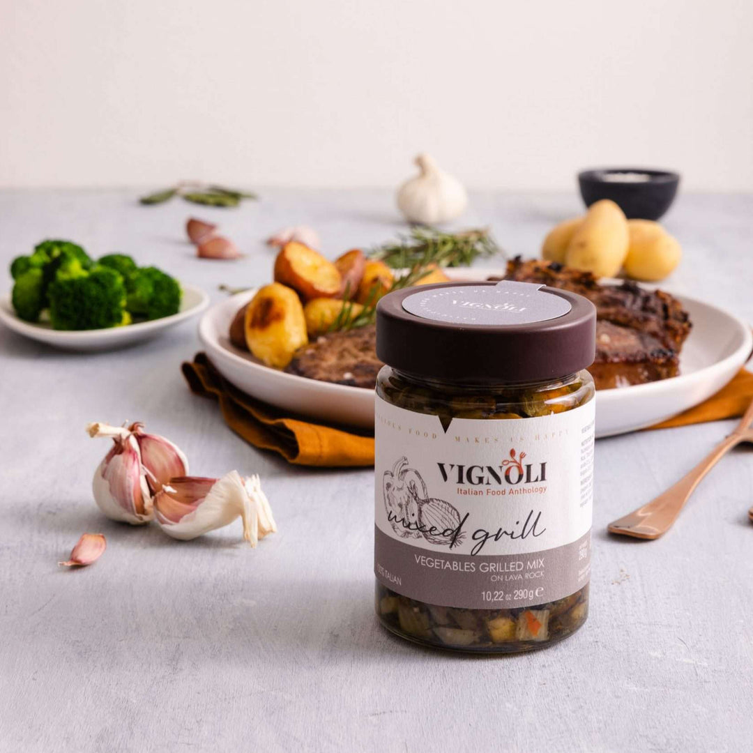 Mixed Grill Vegetables in Olive Oil front of 10.22oz jar on table with steak, potatoes and broccoli in the background
