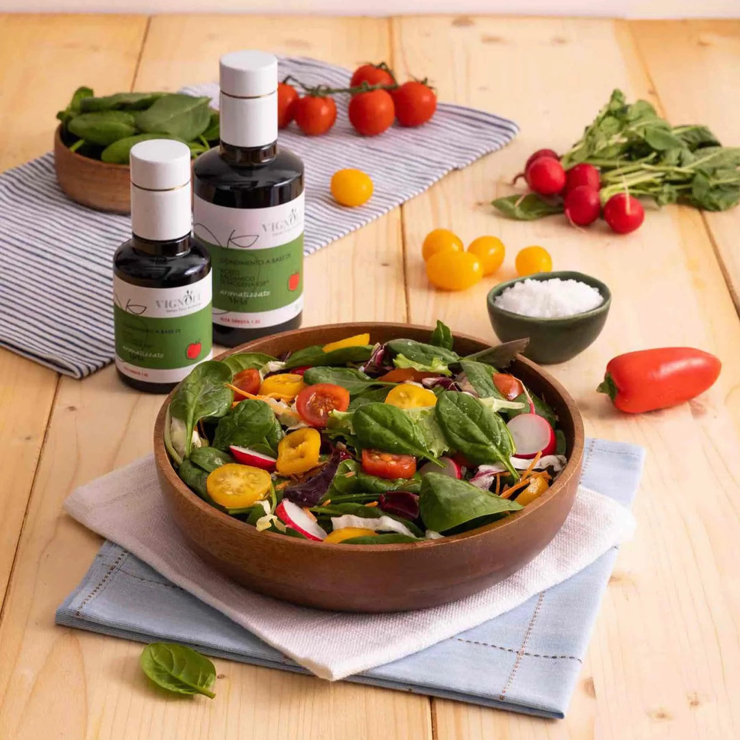Apple Infused Balsamic Vinegar on wooden table with salad in bowl
